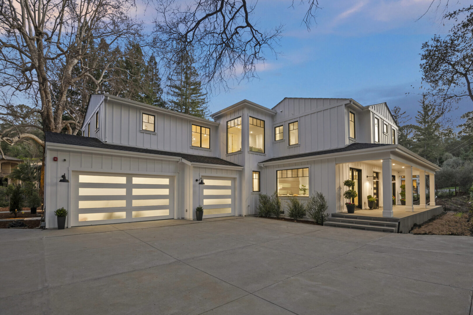 A large white house with two garage doors.