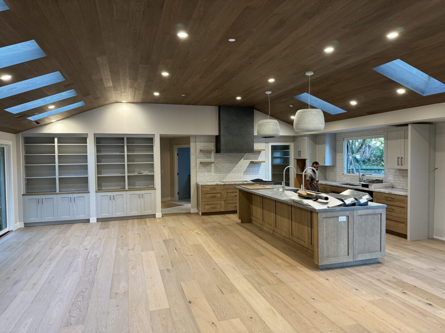 A large kitchen with wooden floors and white cabinets.