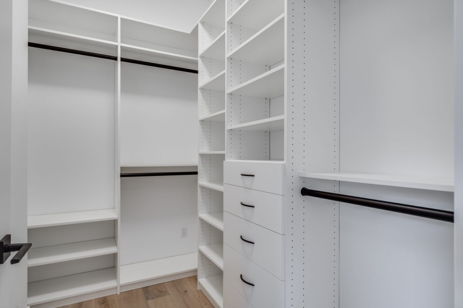 A white closet with shelves and drawers in it