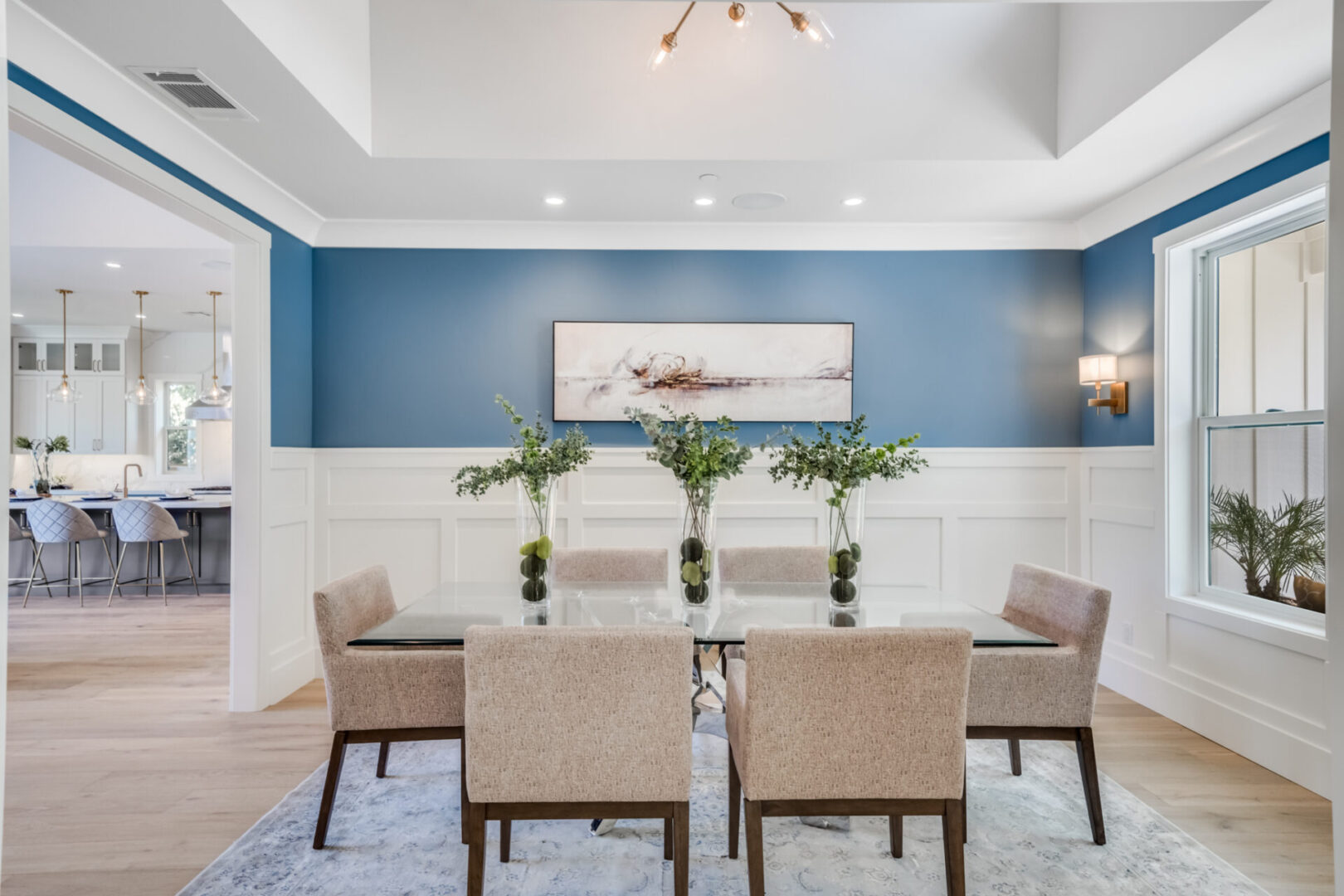 A dining room with blue walls and white trim.